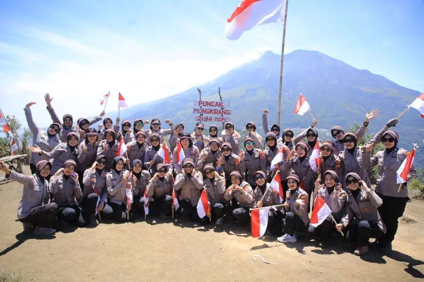 Polwan Polres Madiun Kibarkan Merah Putih dan Bendera Polwan di Puncak Bukit Mongkrang.